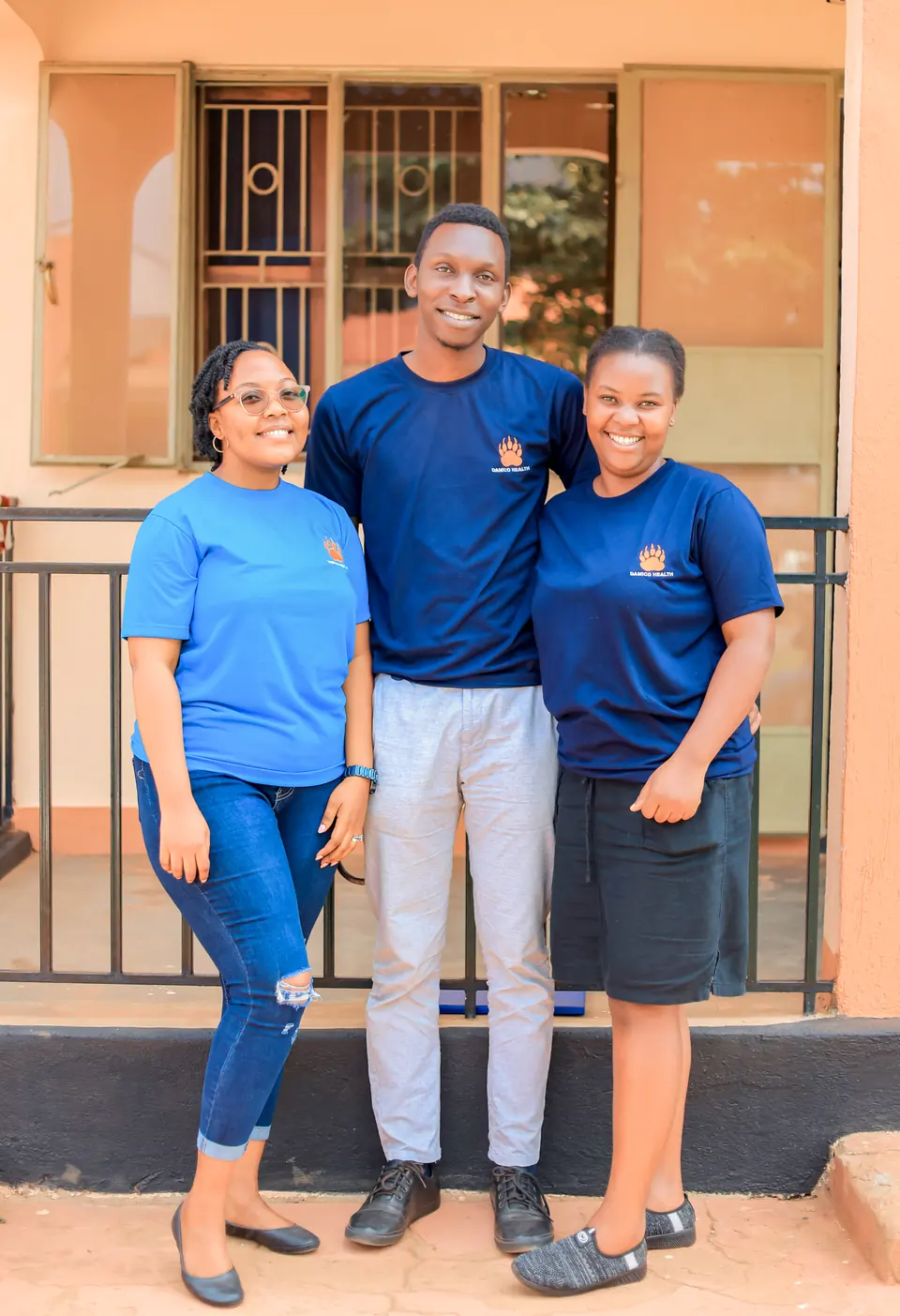 Three members of the Damico Health team stand together outside a clinic building.